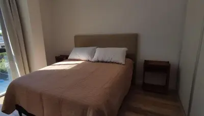 a small bedroom with a bed with a window at Accarezza in Villa Carlos Paz