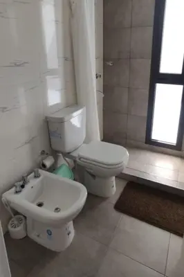 a bathroom with a white toilet and a sink at Accarezza in Villa Carlos Paz