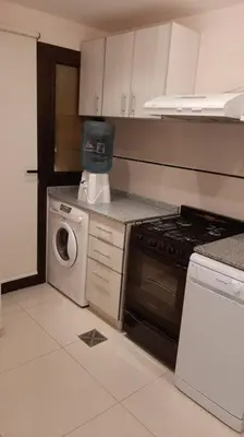 a kitchen with a stove and a washing machine at Céntrico y totalmente equipado depto en Río Cuarto in Río Cuarto