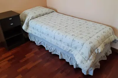 a bed in a bedroom with a wooden floor at Céntrico y totalmente equipado depto en Río Cuarto in Río Cuarto