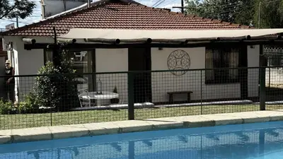 a house with a fence next to a swimming pool at CABAÑA PREMIUM in Villa Carlos Paz