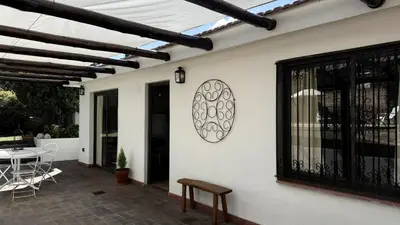 a patio with a table and chairs and a clock on a wall at CABAÑA PREMIUM in Villa Carlos Paz