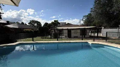 a large swimming pool in front of a house at CABAÑA PREMIUM in Villa Carlos Paz