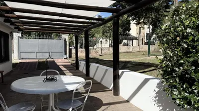 a white table and chairs under a wooden pergola at CABAÑA PREMIUM in Villa Carlos Paz