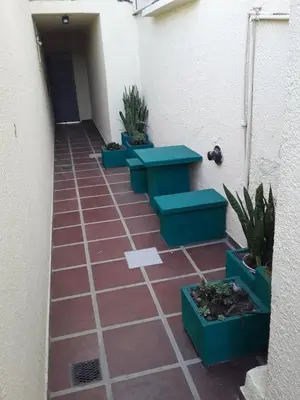 a walkway with blue benches and potted plants at El Dpto de Gabicito in Cordoba
