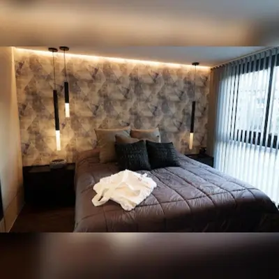 a bedroom with a large bed with a stone wall at Ópera Park royal life in Cordoba