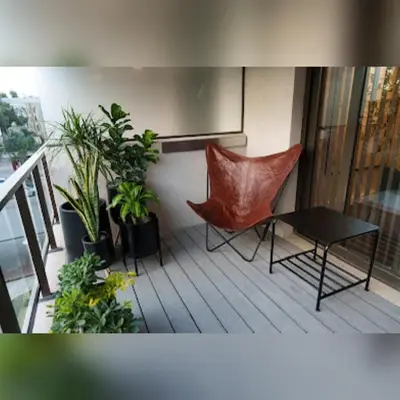a balcony with a chair and a table and plants at Ópera Park royal life in Cordoba