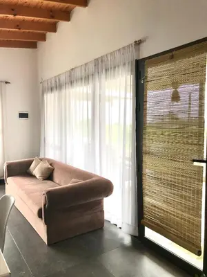 a living room with a couch and a large window at Agave Serrano in Villa Rumipal