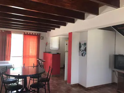 a dining room with a table and chairs at Carlos Paz, Villa Santa Cruz del Lago in Villa Carlos Paz