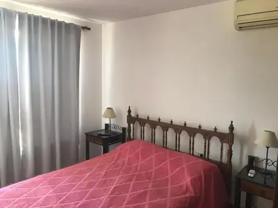 a bedroom with a bed with a red bedspread at Carlos Paz, Villa Santa Cruz del Lago in Villa Carlos Paz