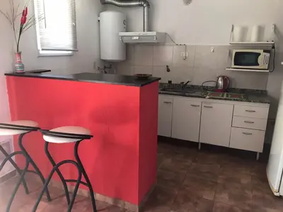 a red counter in a kitchen with a red wall at Carlos Paz, Villa Santa Cruz del Lago in Villa Carlos Paz