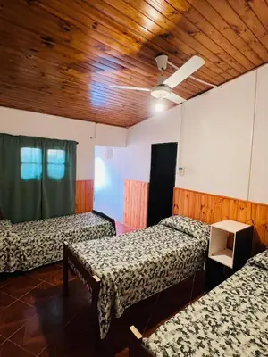 a room with three beds and a wooden ceiling at Los Velitos in Santa Rosa del Conlara