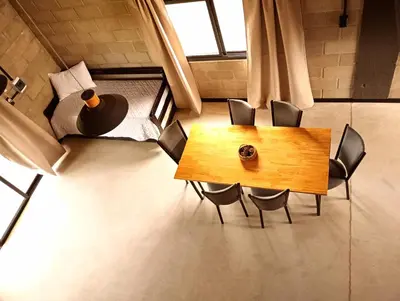 a wooden table and chairs in a room with a window at ALMA Posada in Almafuerte