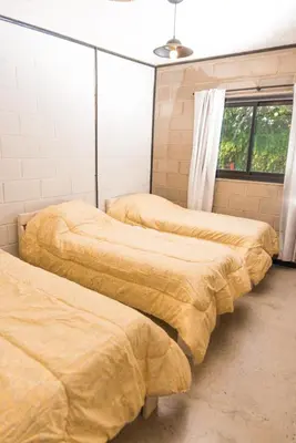 three beds are lined up in a room at ALMA Posada in Almafuerte
