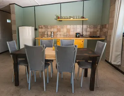 a table and chairs in a room with a kitchen at ALMA Posada in Almafuerte