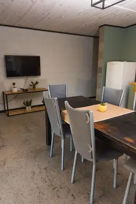 a dining room with a wooden table and chairs at ALMA Posada in Almafuerte