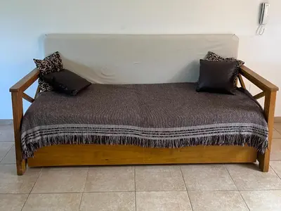 a wooden bed with pillows on it in a room at Departamento Familiar!! Excelente entorno!! (#35) in Villa Carlos Paz