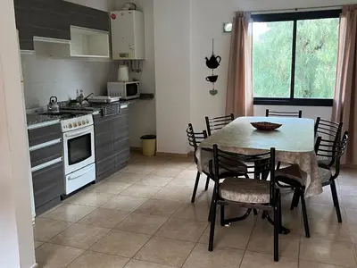 a kitchen with a table and chairs in a kitchen at Departamento Familiar!! Excelente entorno!! (#35) in Villa Carlos Paz