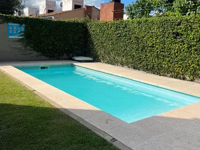 a small blue swimming pool next to a hedge at Departamento Familiar!! Excelente entorno!! (#35) in Villa Carlos Paz