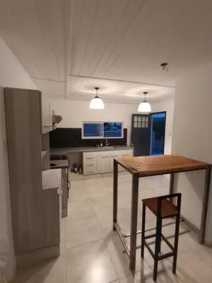 a kitchen with a wooden table and a wooden chair at La casita de balcones in Villa Independencia
