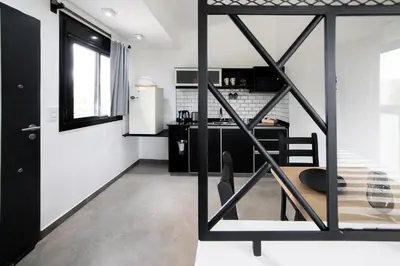 a black and white kitchen with a refrigerator at El Refugio Apart in Villa Serranita