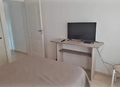 a room with a table with a television on it at Departamentos Vila in Mina Clavero
