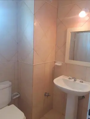 a bathroom with a sink and a toilet and a mirror at Departamentos Vila in Mina Clavero