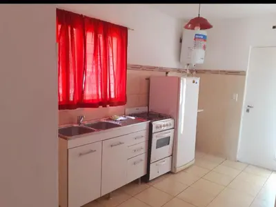 a kitchen with a sink and a stove and a refrigerator at Departamentos Vila in Mina Clavero