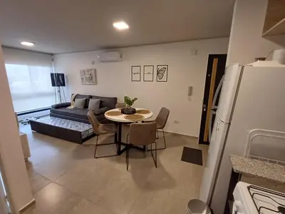 a living room with a table and a couch at SERIETÁ 1 dormitorio con pileta y terraza in Cordoba