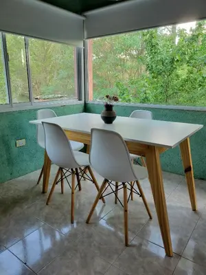 a table and chairs in a room with a large window at Departamento El Colibrí in Arroyo de Los Patos