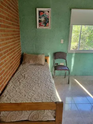 a bedroom with a bed and a chair in it at Departamento El Colibrí in Arroyo de Los Patos
