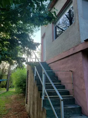 a set of stairs to a house with a window at Departamento El Colibrí in Arroyo de Los Patos