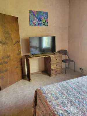 a bedroom with a television and a desk with a chair at Departamento El Colibrí in Arroyo de Los Patos