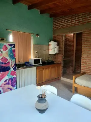 a kitchen with a table and a counter top at Departamento El Colibrí in Arroyo de Los Patos