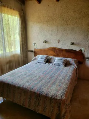 a bed with a wooden headboard in a bedroom at Departamento El Colibrí in Arroyo de Los Patos