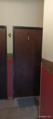 a large wooden door in a room with a wall at Casa de Campo Mama Lucia in Villa Anizacate