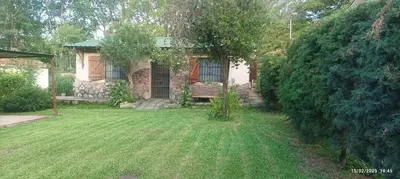 a house with a grass yard in front of it at Casa de Campo Mama Lucia in Villa Anizacate