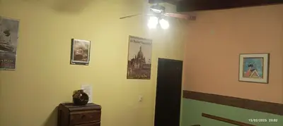 a room with a ceiling fan and pictures on the wall at Casa de Campo Mama Lucia in Villa Anizacate