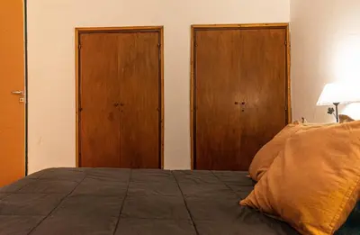 a bedroom with a bed and two wooden doors at Meraki Classic in Villa Carlos Paz