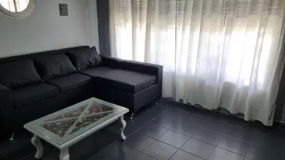 a living room with a black couch and a coffee table at Casa en Potrero de Garay con pileta a 100mt Rio San Pedro in Potrero de Garay