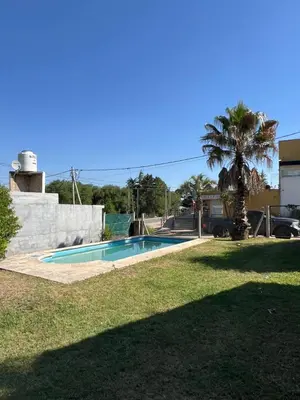 a swimming pool in a yard with a palm tree at Casa en Potrero de Garay con pileta a 100mt Rio San Pedro in Potrero de Garay