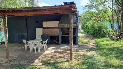 a patio with a table and chairs and a building at Casa en Potrero de Garay con pileta a 100mt Rio San Pedro in Potrero de Garay