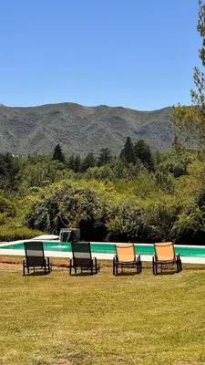 a group of chairs sitting next to a swimming pool at La Jacinta posada suites in Santa Rosa de Calamuchita