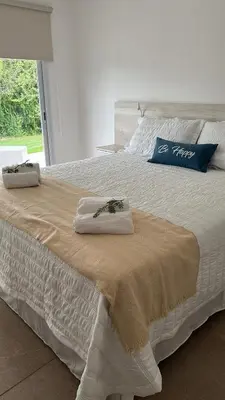 a white bed with two towels on top of it at La Jacinta posada suites in Santa Rosa de Calamuchita