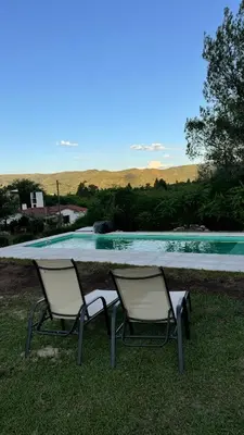 two chairs sitting next to a swimming pool at La Jacinta posada suites in Santa Rosa de Calamuchita