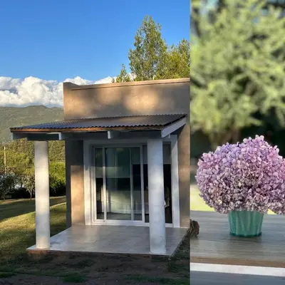 a small building with a vase of purple flowers at La Jacinta posada suites in Santa Rosa de Calamuchita