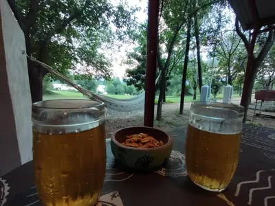 two glasses of beer on a table with a bowl of nuts at La Cabañita Córdoba in Villa Rumipal