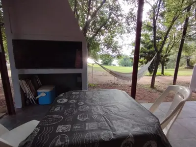 a tent with a table and chairs and a hammock at La Cabañita Córdoba in Villa Rumipal