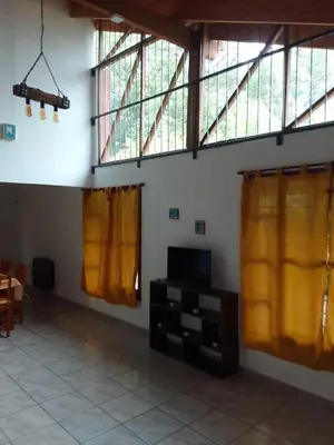 a living room with yellow curtains and a table at El Elyon Duplex in Santa Rosa de Calamuchita
