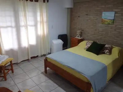 a bedroom with a large bed and a brick wall at El Elyon Duplex in Santa Rosa de Calamuchita